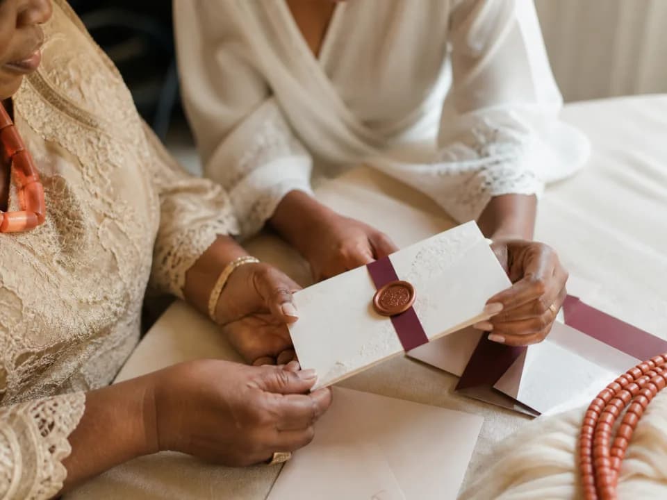Nigerian bride-to-be and family member reviewing wedding invitations